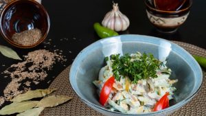 Delicious vegetable salad garnished with fresh herbs and served in a ceramic bowl.